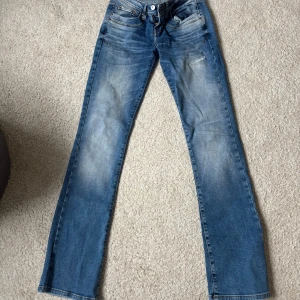 Blå bootcut jeans från LTB Valerie - Snygga blå bootcut jeans från LTB, modell Valerie. Jeansen har låg midja, klassisk femficksdesign och slitningar framtill för en cool look.  Storlek 25/34 jag är 170 för referens och dom passar mig bra!