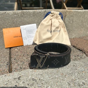 Louis Vuitton svart monogram skärp - Säljer ett svart Louis Vuitton bälte med klassiskt monogrammönster och stor LV-spänne i silver. Bältet är gjort i skinn och har tydliga Louis Vuitton-detaljer. Perfekt accessoar för dig som gillar exklusiva märken. Kvitto och dustbag finns! Allt på bilderna medföljer. Använt men har mycket kvar att ge! Om det är något mer du undrar så är det bara att skriva😃