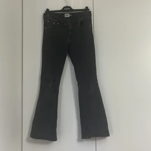 Svarta bootcut jeans från 157 - Svarta jeans från 157 med  bootcut-modell och låg midja. Klassisk femficksdesign och diskreta sömmar. Jeansen har en något utsvängd benslut och är perfekta för en avslappnad stil. De är lite slitna mellan benen och nere vid fötterna men inget som syns, i storlek M/short 