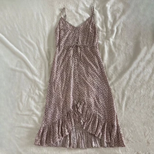 Blommig volangklänning från Rails - Säljer en söt blommig midi klänning från Rails i storlek XS. Klänningen har smala axelband, v-ringning och volangdetaljer längs nederkanten. Mönstret är småblommigt i rosa och vitt. Perfekt för varma dagar! Midja: 32cm Längd (längsta delen): 88cm Nypris ca 2500