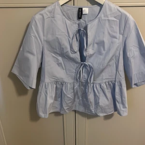Ljus blå blus  - Säljer denna söta eleganta blus toppen som har en stilren modell. Blusen passar till festliga tillfällen eller bara något man vill ha över. Aldrig använt 