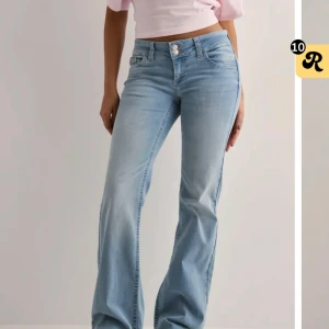 Ljusblå lågmidjade bootcut jeans - Säljer ett par ljusblå bootcut jeans från Nelly. Med rosa detaljer. Jeansen är lågmidijade och endast använda fåtal gånger!💞💞