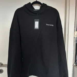 Svart Hoodie Med Text - helt oanvänd, hundhåren tas bort före köp.