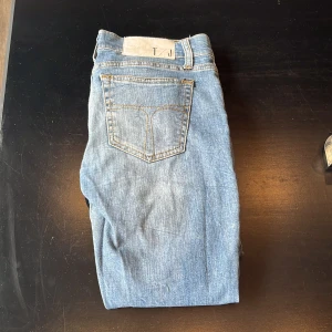 Ljusblå jeans från Tiger of Sweden - Säljer ett par ljusblå skinny jeans från Tiger of Sweden. Jeansen har klassisk femficksdesign, gylf med dragkedja och smal passform. Perfekta för dig som gillar en stilren och enkel look.