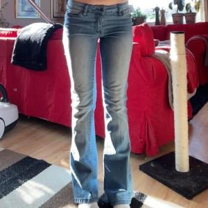 Ljusblå bootcut jeans - Säljer ett par ljusblå jeans med bootcut passform och låg midja. Jeansen har klassiska fem fickor, dragkedja och knapp framtill. 