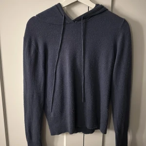 Blå stickad hoodie  - Mysig blå stickad hoodie i cashmere från Rosemunde med långa ärmar och luva. Perfekt för en avslappnad stil och enkel att matcha med jeans eller leggings.