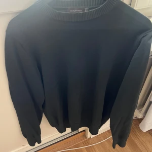 Tröja Oscar Jacobson - Klassisk grön tröja från Oscar Jacobson med rund halsringning och ribbade muddar. Enkel och stilren design som passar perfekt till många olika outfits. Tröjan har lång ärm och är tillverkad i ett mjukt material. Varan är köpt för 849kr och jag säljer den för 649kr. Jag har använt ungefär 5 gånger så den är väldigt fräsh samt ny.