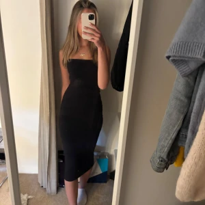 Svart tubklänning från Gina Tricot - Säljer en svart, tight tubklänning från Gina Tricot i storlek M. Klänningen är axelbandslös och har en kroppsnära passform som slutar under knäna. Perfekt för dig som gillar en stilren och enkel look. Även om det står M så passar den xs/s men även större pga att den är stretchig❤️