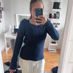 Mörkblå stickad tröja från ONLY - Säljer en mörkblå stickad tröja från ONLY med kabelstickat mönster upptill. Tröjan har rund halsringning och långa ärmar. Perfekt för kyligare dagar och enkel att matcha med olika outfits.