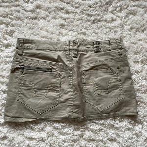 Kjol från Cropp - Säljer en ljus grön kjol från Cropp med klassiska jeansfickor bak och fram, samt en liten dragkedjedetalj på ena bakfickan. Knappt använd! ☺️