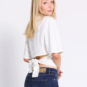 Vit omlottopp med knyt i ryggen - Superfin vit omlottopp med kort ärm och snygg knytning i ryggen. Toppen har en croppad passform och ger en fräsch och stilren. Aldrig använd säljer också en sån svart🤗