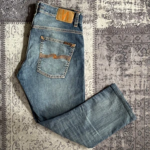Nudie jeans  - Fint par nudie jeans i nyskick med fin tvätt och färg. Jeansen är i storlek 32/30 men är uppsydd och där av lite kortare. Modellen på jeansen är grimtrim. Hör gärna av dig vid funderingar!