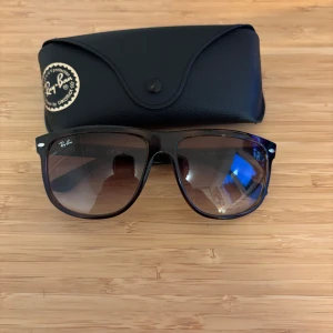 Ray-Ban Boyfriend - Snygga Ray-Ban solglasögon med brun tonad lins och klassisk fyrkantig form. Modell: rayban boyfriend.  Bågarna är mörkbruna med diskreta detaljer i silver vid skruvarna. Kommer med original svart fodral. Perfekt för dig som vill ha en cool och tidlös look. (RB 4147 710/51 60 [] 15 145 2N)