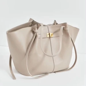 Gina väska beige  - Den är andvänd och det syns på strapsen men det är fortarande en väska som funkar och är jättefin annars fortande