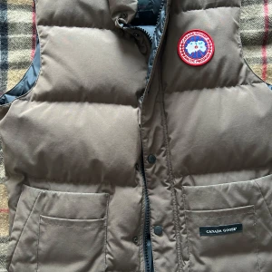 Canada goose dunväst  - Brun grön Canada goose dunväst, passar riktigt bra inför våren och även början av vintern. Tyvärr så finns kvitto inte men den är 100% äkta skicka frågor vid funderingar så svarar jag så snabbt som möjligt 🙏