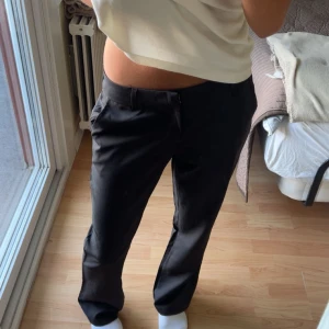 Svarta kostymbyxor i XS - Säljer ett par svarta kostymbyxor i storlek XS. Byxorna har raka ben, hällor för bälte och sidfickor. Snygg och stilren modell som sitter midja till höft. Perfekta till en clean och enkel look.