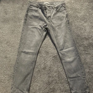 Grå jeansbyxor från Mango - Snygga grå jeansbyxor från mango, modell BOB. Klassisk femficksdesign med raka ben och normal passform. Jeansen har bälteshällor och dragkedja i gylfen. Perfekt för dig som gillar en enkel och stilren look.