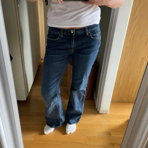 Blå Esprit bootcut jeans - Snygga blå jeans från Esprit med bootcut-modell och låg midja. Jeansen har klassiska fickor fram och bak, med dekorativa sömmar på bakfickorna. Tillverkade i mjukt denim med en skön passform. Perfekta för dig som gillar en avslappnad men trendig stil.