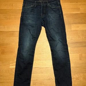 Mörkblå slim jeans Jack & Jones 30/30 - Snygga mörkblå jeans från Jack & Jones, modell Slim/Glenn. De har klassisk femficksdesign, smal passform och är gjorda i mjukt bomullsmaterial med lite stretch. Perfekta för dig som gillar en modern och stilren look.