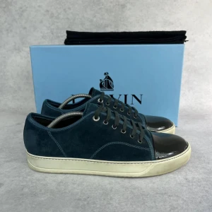 Lanvin DBB1 cap toe sneaker - – Condition: 9/10  - Size: 43/UK9  – What is included: Dustbag  – Retail price: 6000 + SEK  Please note that Lanvins fit big and our recommendation is to go one size down
