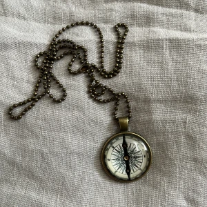 Vintage statement halsband med kompass - SÅ coolt och unikt halsband med en rund kompass som hängsmycke. Kedjan är i antikguld-färgad metall med små kulor och kompassen har detaljer i svart och vitt.  Supersnyggt att använda för layering med andra smycke. Perfekt om du vill ha något som sticker ut i din smyckesamling, speciellt nu på hösten!! 🤎🕰️🎞️☕️