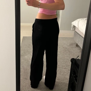 Svarta vida linnebyxor - Säljer ett par svarta linnebyxor med breda ben och elastisk midja som kan skysteras. Använda 2 gg 