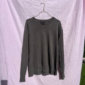 Gråbrun v-ringad tröja från Banana Republic - Snygg gråbrun v-ringad tröja från Banana Republic i 100% bomull. Tröjan har ribbade muddar vid hals, ärmslut och nederkant samt lång ärm. Perfekt för lager-på-lager och enkel att matcha med jeans eller chinos.
