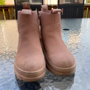 Rosa boots från hm  med dragkedja - Snygga rosa boots från hm med grov sula och dragkedja på sidan. Skorna är fodrade med mjukt material på insidan och har praktiska öglor baktill. Perfekta för kyligare dagar och ger en cool touch till din outfit.