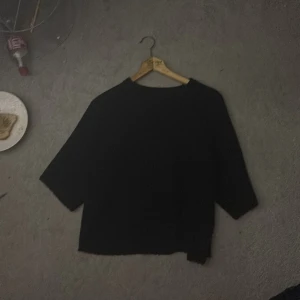 Svart tröja från 157 med trekvartsärm - En stilren svart tröja från 157 med trekvartsärmar och rak passform. Perfekt för dig som gillar enkel och clean look. Tröjan har rund halsringning och är lätt att matcha med både jeans och kjol.