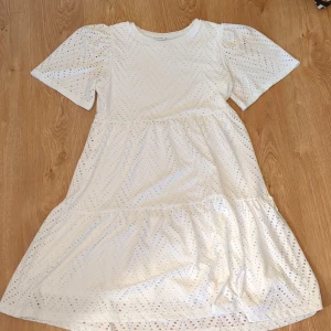Vit klänning från JDY stl. M - Superfin vit klänning från JDY med puffiga korta ärmar. Klänningen har rund halsringning. Stl. M