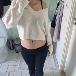 Vit croppad stickad tröja Divided XS - Säljer en vit croppad stickad tröja från Divided, H&M. Tröjan har v-ringning, långa ärmar och en loose fit som ger en chill offshoulder-look. Perfekt till jeans eller kjol för en avslappnad vibe.