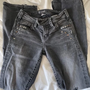 Grå bootcut jeans med nitar - Snygga grå jeans från Replay med bootcut passform och coola nitar på fickorna fram och bak. Dom har tecken på användning men fortfarande i bra skick. Jeansen är utsydda också vilket syns vid benen (se bild). Hör av dig om du har frågor eller för fler bilder.🩷