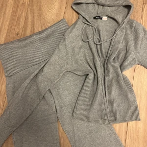 Grå stickade mjukisbyxor Gina Tricot oanvända  - Mysiga grå stickade mjukisbyxor från Gina Tricot med bred ribbad midja och raka ben. Perfekta för chill dagar hemma, supermjuka och stretchiga. Matcha med hoodie för en komplett lounge-look, helt oanvända 