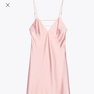 Ljusrosa satinklänning från Zara - Supersnygg ljusrosa långklänning i satin från Zara. Klänningen har en slät, glansig yta och är ärmlös med smala axelband. Den har en elegant, figurnära passform upptill och faller snyggt nedtill. Perfekt för dig som vill ha en stilren och trendig look.