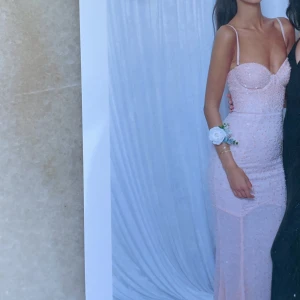 Ljusrosa glittrig långklänning - Säljer världens finaste klänning från Oh Polly, enbart använd en gång på ett bröllop och är i nytt och super bra skick! Köpt för 2112 kr (inklusive frakten) 🩷, banden går att ta av så att det blir en bandeau klänning!