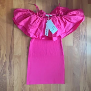 Rosa offshoulder klänning från Zara - Superfin rosa kortklänning från Zara med offshoulder och volang upptill. Klänningen har smala axelband och en figurnära passform 