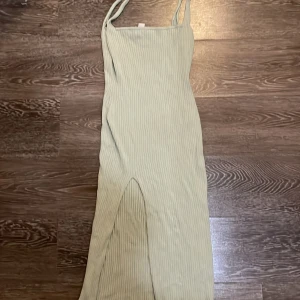 Ljusgrön ribbad långklänning H&M Divided - Supersnygg ljusgrön ribbad långklänning från H&M Divided. Klänningen har smala axelband, en tight passform och en slits framtill som ger en cool vibe. Perfekt för varma dagar när du vill vara både bekväm och trendig. Mjukt och stretchigt material. Kameran tog inte upp färgen på klänningen så bra men det är turkos färg.