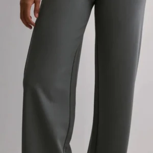 Grå wide byxor i mjukt material - Snygga grå byxor med wide passform och raka ben. Byxorna har en enkel och stilren look, perfekta för en chill och trendig outfit. Tillverkade i ett mjukt och följsamt material som ger en skön känsla hela dagen.