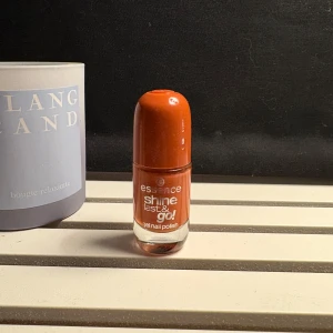 Essence orange nagellack Shine Last & Go - Essence Shine Last & Go gel nail polish i en snygg orange nyans. Kommer i en rund glasflaska med orange plastlock. Perfekt för dig som vill ha glansiga och hållbara naglar med en poppig färg.