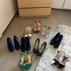 Mix av klackskor och boots i olika färger - Säljer flera par klackskor och boots i olika färger och modeller. Här finns blåa boots i mocka, svarta boots med snörning, gröna sandaler med spänne, silvriga och svarta sandaler med klack, samt pumps i svart spets, silver och korall. Perfekt för dig som vill variera din stil.