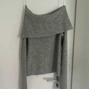 Grå offshoulder stickad tröja BikBok - Supermysig grå stickad tröja från BikBok i ullblandning. Offshoulder-modell. Kan funka som M