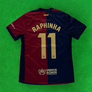 FC Barcelona Raphinha matchtröja Nike - Snygg FC Barcelona matchtröja med Raphinha och nummer 11 på ryggen. Tröjan är kortärmad och har klassiska blå och röda paneler, klubbmärke och Nike-logga framtill samt sponsorer i guld. Tillverkad i lätt och ventilerande polyester, perfekt för fotbollsplanen.
