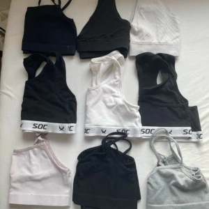 10 toppar från SOC, bale, H&M och Kappahl  - ( 10-30 kr st )Säljer ett paket med 10 toppar i svart, vitt, grått och ljusrosa. Flera har brottarrygg och bred resår med SOC-logga, andra har smala axelband. Perfekta för träning eller chill. Materialet är mjuk bomull och syntet, vissa ribbade. Snygga basplagg för garderoben.