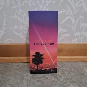 Louis Vuitton City of Stars parfym - Exklusiv parfym från Louis Vuitton, City of Stars. Flaskan är cylindrisk i glas med svagt rosa doftvätska och svart lock. Ytterkartongen har en snygg gradient i lila, rosa och orange med palmmotiv och stadssilhuett. Kommer i elegant vit förpackning.