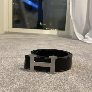 Ett svart snyggt bälte med H - Helt nytt skick jag skickar med plast skydd på H delen på bältet! Tveka inte vid frågor