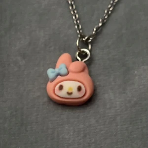 Sanrio My Melody Halsband Choker cute - Sött halsband med en liten berlock av My Melody. Berlocken är ca 1 x 1 cm. Trädd på kedja i silver imitation som är justerbar 35-40 cm, så du kan välja om det ska sitta som en choker eller lite längre ned. 