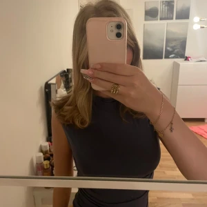 Mörkblå ärmlös topp Gina Tricot strl M - Supersnygg mörkblå ärmlös topp från Gina Tricot i storlek M. Modellen är slim. Materialet är mjukt och stretchigt bomull, perfekt för att matcha med jeans eller kjol. Enkelt att styla och passar dig som gillar minimalistiskt.