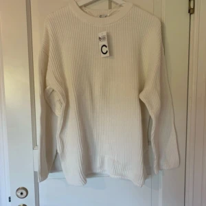 Vit ribbstickad tröja från Cubus - En stilren vit ribbstickad tröja med rund hals och lång ärm. Tröjan har en relaxed passform och är perfekt för lager-på-lager. Materialet känns mjukt och passar dig som gillar en enkel men snygg look.