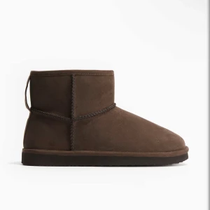 Mörkbruna Uggs  - Säljer dessa jättefina mörkbruna uggsen från hm. Ingen tecken på användning Skirv för bilder. Dem är helt slut sålda.💕