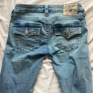 True Religion jeans - Ljusblå jeans från True Religion, modell Joey Low Rise Flare i storlek 23💓med fickor där back! Köpte dom i april och jag har inte använt dom så mycket, de är som nya förutom att det är ett litet hål längst när på byxorna som man ser på sista bilden men det är absolut inte något man tänker på❣️